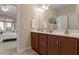 Bathroom featuring wooden cabinetry, dual sinks and adjacent sunroom at 228 Ellisview Dr, Cary, NC 27519