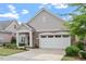 Charming home featuring stone accents, a covered porch, manicured lawn, and an attached two-car garage at 228 Ellisview Dr, Cary, NC 27519
