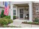 Inviting front porch featuring stone accents, a rocking chair, manicured landscaping, and decorative plants at 228 Ellisview Dr, Cary, NC 27519