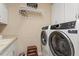 Laundry room featuring modern washer and dryer units, shelving and sink at 228 Ellisview Dr, Cary, NC 27519