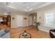 Open living room with hardwood floors, recessed lighting, and an open view to the kitchen and the doors at 228 Ellisview Dr, Cary, NC 27519