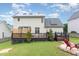 Backyard view featuring a deck, patio, and grassy area, with solar panels visible on the roof at 2301 Laurel Valley Way, Raleigh, NC 27604