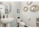 Bathroom with stylish pedestal sink, toilet, and decorative mirrors on a neutral-toned wall at 2301 Laurel Valley Way, Raleigh, NC 27604
