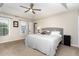 Bedroom boasts a comfortable king-size bed, neutral carpet, and tray ceiling with modern ceiling fan at 2301 Laurel Valley Way, Raleigh, NC 27604