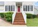 Front steps leading to a red front door with lush landscaping and white railing at 2301 Laurel Valley Way, Raleigh, NC 27604
