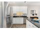 View of the kitchen with stainless steel refrigerator and sink with white cabinets and tile backsplash at 2301 Laurel Valley Way, Raleigh, NC 27604