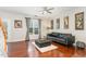 Comfortable living room featuring a black leather sofa, wood floors, and natural light at 2301 Laurel Valley Way, Raleigh, NC 27604