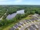 Aerial view features houses next to a serene lake with lush green surroundings at 2426 Heron Watch Pl, Fuquay Varina, NC 27526