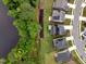 Aerial view of homes near a lake with solar panels and green landscaping at 2426 Heron Watch Pl, Fuquay Varina, NC 27526