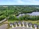Aerial view of a neighborhood and bridge near a lush, wooded area and lake at 2426 Heron Watch Pl, Fuquay Varina, NC 27526