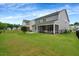 Expansive green backyard with black fence, patio, and screened-in porch at 2426 Heron Watch Pl, Fuquay Varina, NC 27526