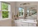 Elegant bathroom featuring a vanity with white countertops, modern fixtures, and serene green views at 2426 Heron Watch Pl, Fuquay Varina, NC 27526