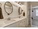 Modern bathroom with dual sinks, white cabinetry and two decorative mirrors at 2426 Heron Watch Pl, Fuquay Varina, NC 27526