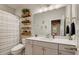 Well-lit bathroom featuring a white vanity, large mirror, and modern fixtures at 2426 Heron Watch Pl, Fuquay Varina, NC 27526