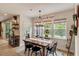 Inviting dining area with wood table and decorative accents, illuminated by natural light from large windows at 2426 Heron Watch Pl, Fuquay Varina, NC 27526