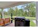 Screened porch with a sleek Blackstone grill and seating area overlooking the backyard at 2426 Heron Watch Pl, Fuquay Varina, NC 27526