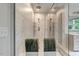 Sleek glass shower with marble tile and dual shower heads for a luxurious spa-like bathroom at 2426 Heron Watch Pl, Fuquay Varina, NC 27526