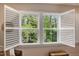 Bright windows with white plantation shutters offering picturesque views of lush greenery at 2426 Heron Watch Pl, Fuquay Varina, NC 27526