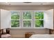 A close up view of a large window with white shutters, offering natural light and green outdoor views at 2426 Heron Watch Pl, Fuquay Varina, NC 27526