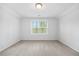 A bright, carpeted bedroom features a window letting in ample natural light, enhancing the room's airy feel at 247 Axis Deer Ln, Garner, NC 27529
