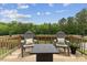 Back deck with gray Adirondack chairs and a small coffee table overlooking the backyard at 260 Amber Acorn Ave, Raleigh, NC 27603