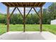A covered patio with wooden support beams overlooking a green lawn and a wooded area at 260 Amber Acorn Ave, Raleigh, NC 27603