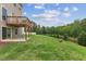Spacious backyard with lush green lawn, mature trees, and a wooden deck, perfect for outdoor living at 260 Amber Acorn Ave, Raleigh, NC 27603