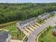 Aerial shot of well-maintained townhomes featuring attached garages and neatly landscaped front yards near a lush green space at 260 Amber Acorn Ave, Raleigh, NC 27603