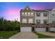 Charming townhome featuring a brick facade, two-car garage, manicured lawn, and covered entrance at 260 Amber Acorn Ave, Raleigh, NC 27603