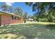 View of the backyard featuring a lush lawn and mature trees, showcasing the home's serene outdoor space at 28 White Oak Dr, Smithfield, NC 27577