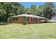 Charming brick home on a lush green lawn surrounded by mature trees, offering privacy and curb appeal at 28 White Oak Dr, Smithfield, NC 27577