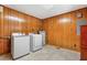 Laundry room featuring wood-paneled walls, a washer, dryer, and water heater at 28 White Oak Dr, Smithfield, NC 27577