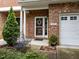 Inviting brick porch featuring decorative columns, a cozy bench, and a beautifully adorned front door at 2950 Settle In Ln, Raleigh, NC 27614