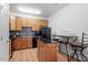Well-lit kitchen features wood cabinets, black appliances, backsplash, and an island with granite countertop at 300 Gilman Ln # 101, Raleigh, NC 27610