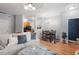Open-concept living room with a sofa, hardwood floors, and a seamless connection to the kitchen at 300 Gilman Ln # 101, Raleigh, NC 27610