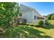 Charming home exterior with a well-kept lawn, mature trees, and a cozy patio area for outdoor relaxation at 3002 Bartlett Cir, Hillsborough, NC 27278