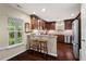 Well-lit kitchen features dark cabinets, granite countertops, stainless appliances, and a breakfast bar at 3002 Bartlett Cir, Hillsborough, NC 27278