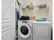 Bright laundry room with modern washer and dryer units, shelving, and a broom at 3002 Bartlett Cir, Hillsborough, NC 27278