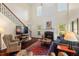 Spacious living room with a fireplace, large windows, and staircase with dark hardwood floors at 3002 Bartlett Cir, Hillsborough, NC 27278