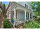 Covered front porch supported by white columns, complemented by lush greenery and stone accents at 3002 Bartlett Cir, Hillsborough, NC 27278