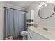 Cozy bathroom with a blue and white striped shower curtain and white shelving and vanity at 3016 Bolo Trl, Raleigh, NC 27615