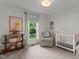 Bright Bedroom features a white crib, comfortable armchair, and natural light from the window overlooking the backyard at 3016 Bolo Trl, Raleigh, NC 27615