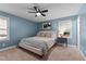 Comfortable bedroom features a modern ceiling fan, blue walls, and plush carpeting for a relaxing retreat at 3016 Bolo Trl, Raleigh, NC 27615