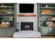Close-up of the fireplace featuring a white brick hearth and custom shelving at 3016 Bolo Trl, Raleigh, NC 27615