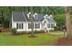 Charming home with dormer windows, a brick chimney, and manicured lawn with mature trees at 3016 Bolo Trl, Raleigh, NC 27615