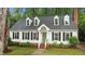 Charming home featuring a green door with a wreath, black shutters and well manicured landscaping at 3016 Bolo Trl, Raleigh, NC 27615