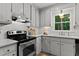 Bright kitchen features white cabinets, subway tile backsplash, stainless steel range, and a view of the wooded exterior at 3016 Bolo Trl, Raleigh, NC 27615