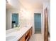 Bright bathroom featuring double sinks, a large mirror, and access to walk-in closet spaces at 3016 Hayling Dr, Raleigh, NC 27610