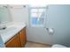 Cozy bathroom with a single sink vanity, mirror, and window at 3016 Hayling Dr, Raleigh, NC 27610