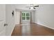 Well-lit bedroom with hardwood floors, a ceiling fan, and a large window at 305 Old School Rd, Chapel Hill, NC 27516